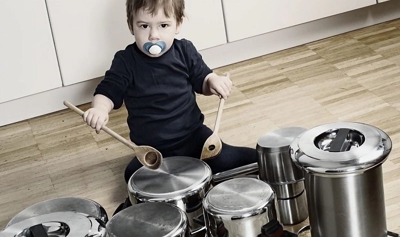 Un enfant de 3 ans joue de la batterie avec un orchestre