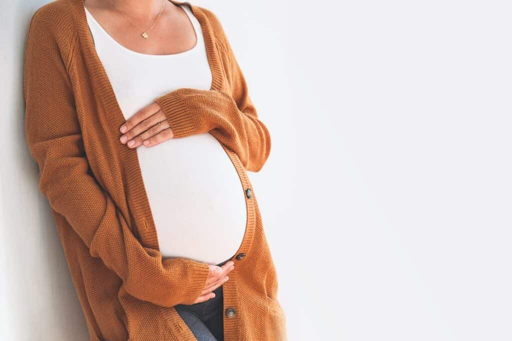 femme enceinte en t-shirt blanc et veste en laine