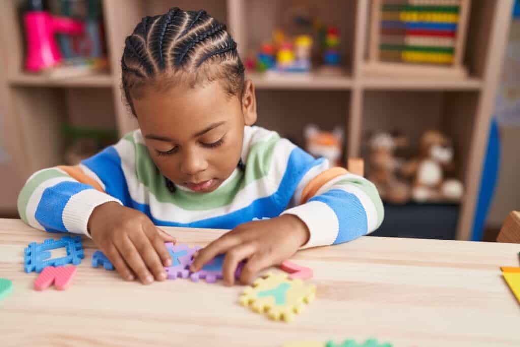 jeune garçon joue au puzzle