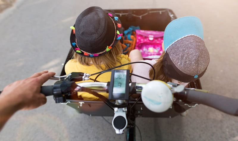 deux enfants dans un vélo cargo