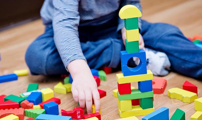 enfant qui joue avec des blocs de constructions