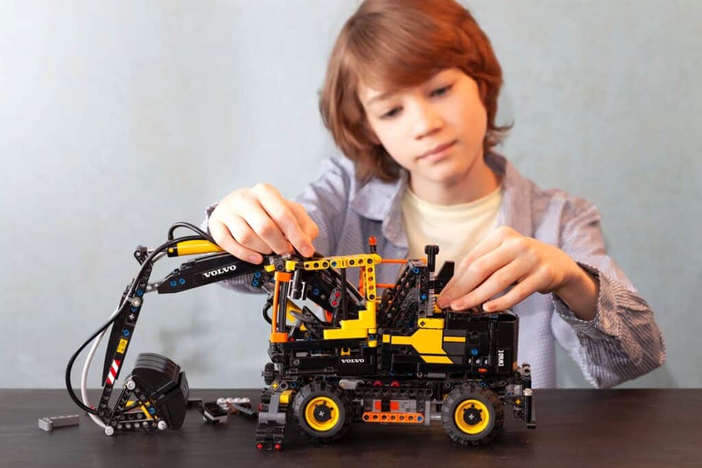 garçon construit pelleteuse Lego Technic