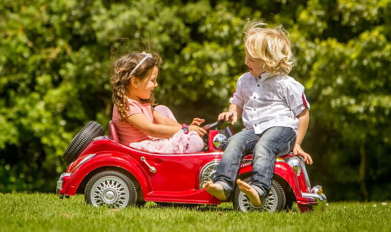 enfants jouant avec une voiture électrique jouet