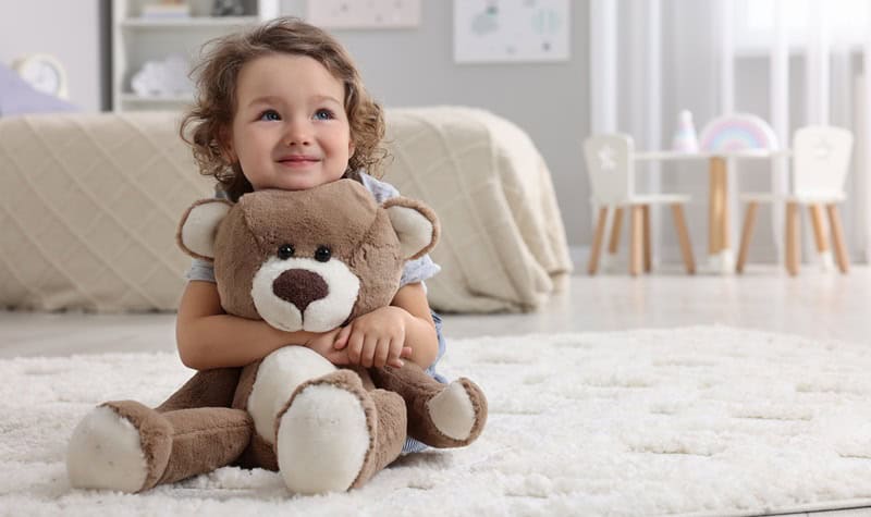 fillette avec une peluche ours dans les bras