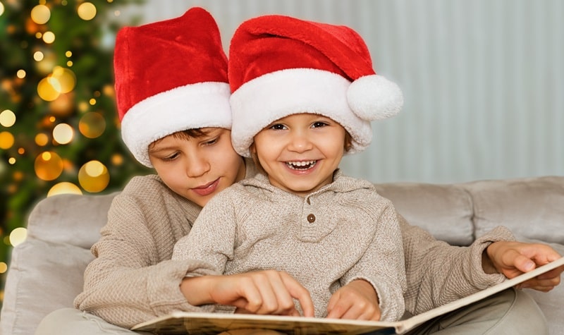 deux enfants avec des bonnets de Noël