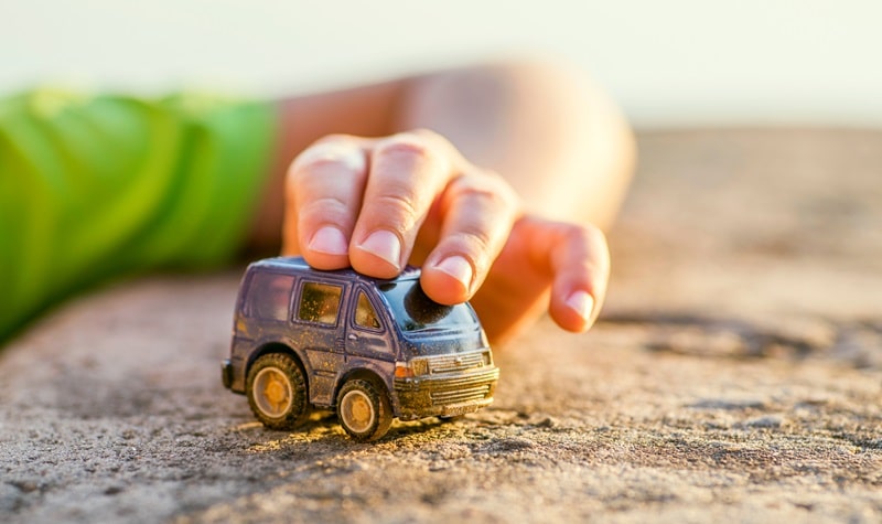 enfant jouant avec une voiture miniature